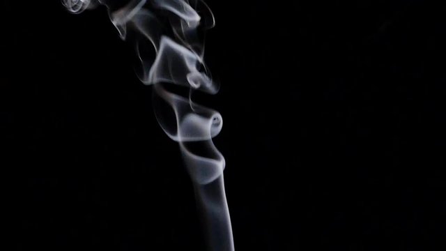 Beautiful gray smoke on a black background. Cigarette smoke. Smoke from the hookah. Turbulence of smoke. The white vapor rises. The smoke slowly flies.