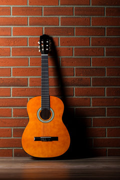 Acoustic guitar leaning against a wall.