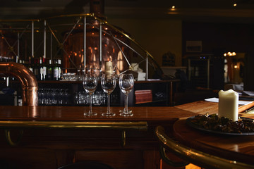 Glass glasses stand in anticipation of a party on the bar with a beautiful elegant interior.