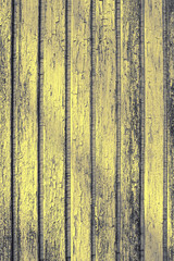 Yellow old grunge cracked wooden fence toned background