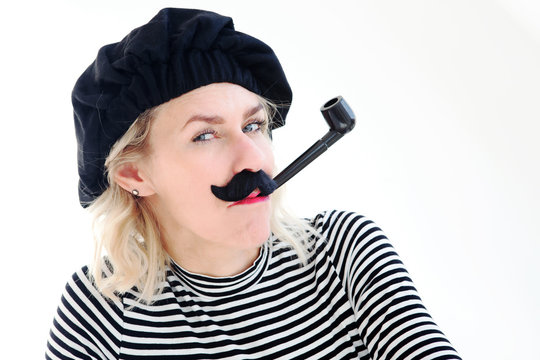 portrait of blond woman as french man with beret, mustache and pipe
