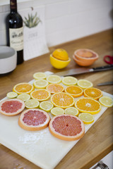Slices of citrus cover a cutting board on the counter