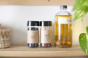 Spices and oil sit on a shelf in the kitchen 