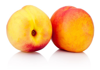 Two nectarine fruit with green leaf isolated on a white background