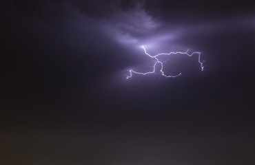 lightning bolts reflection over the sea. taken during a thunderstorm over the ocean with clouds in the background