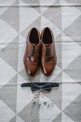 Wedding fashion composition. Groom's shoes, bow tie, bridal rings and eucalyptus branch. Flat lay,...