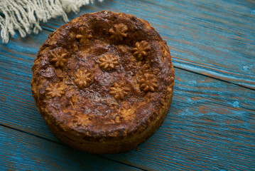 Round Loaf Karavai on wooden rustic table background. Traditional slavic russian and ukranian festivals and weddings bread, close-up