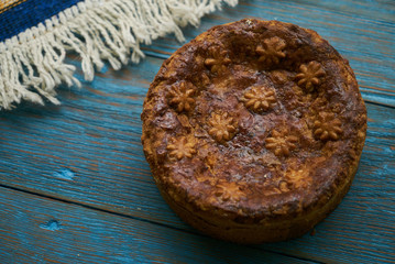 Round Loaf Karavai on wooden rustic table background. Traditional slavic russian and ukranian festivals and weddings bread, close-up
