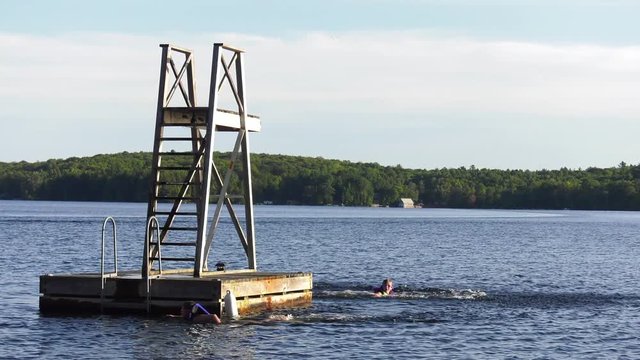 girl jumps from floating tower in lake