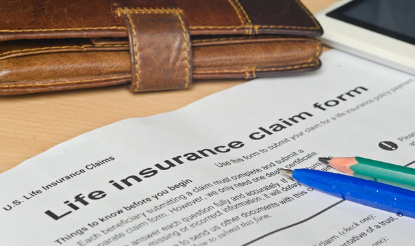 life insurance claim form on a wooden surface