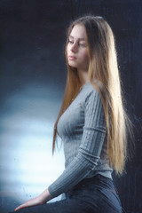 Fototapeta premium A beautiful, young girl is sad for a blind window