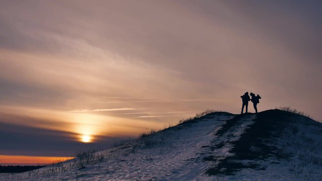 people winter silhouette does selfie photograph joy snow sunlight. group of tourists walking on top of sunset silhouette mountain. slow video tourists people group go travel nature lifestyle