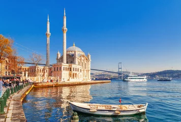 Foto auf Acrylglas Turkei Ortakoy Cami - berühmtes und beliebtes Wahrzeichen in Istanbul, Türkei. Schöne Frühlingslandschaft mit Fischerboot im Vordergrund und alter historischer Moschee Ortakoy und Istanbul Bosporus-Brücke im Hintergrund.