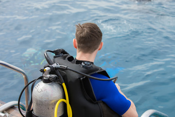 Rear view of man diver with scuba ready to underwater swim