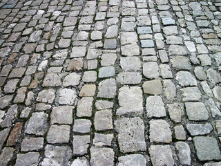 Stone pavement in perspective. Stone pavement texture. Cobblestone pavement background. Abstract background of old cobblestone pavement close-up.    