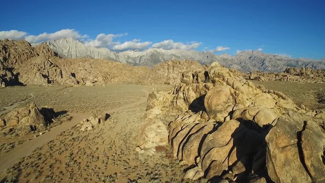 A high aerial shot over the Alabama Hills outside Lone Pine California with Mt. Whitney and Sierras background.