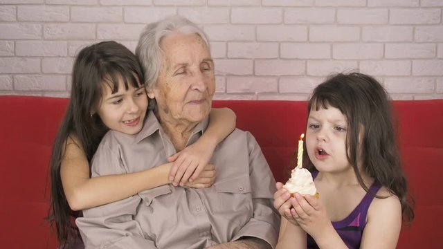 Happy old age. Grandmother's birthday. Children with grandmother. Granddaughter congratulate grandmother on his birthday.