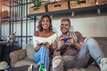 Beautiful couple having fun while playing video games.