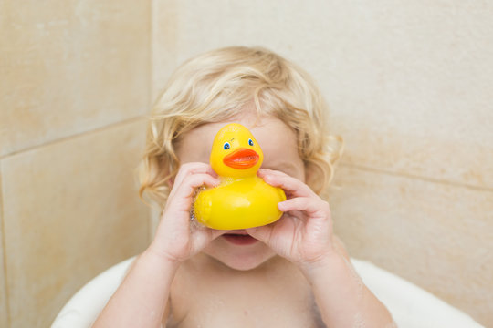 smiling child bathing in the bathroom with foam