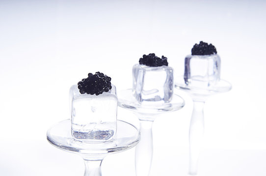 black caviar on ice cubes isolated on white