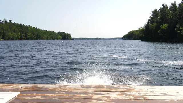 boy and girl holding hands jump into lake slow motion
