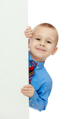 boy peeks out from behind the banner