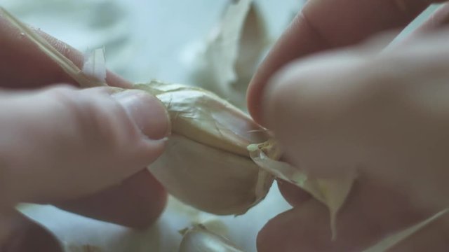 man is cleaning garlic close-up cloves. Vegetarians garlic food in the kitchen indoors lifestyle