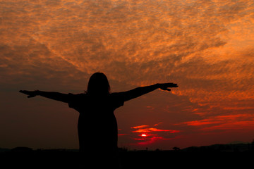 Fototapeta na wymiar Silhouette of woman exercises at sunset Yellow on sky beautiful in summer