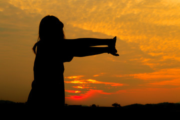 Fototapeta premium Silhouette of woman exercises at sunset Yellow on sky beautiful in summer
