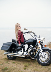 Naklejka na ściany i meble Biker woman outdoor with a motorcycle.