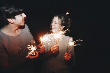 Caucasian man and woman couple playing with sparklers celebration and festive party concept © Rawpixel.com