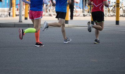 Fototapeta na wymiar marathon runner legs running on city road