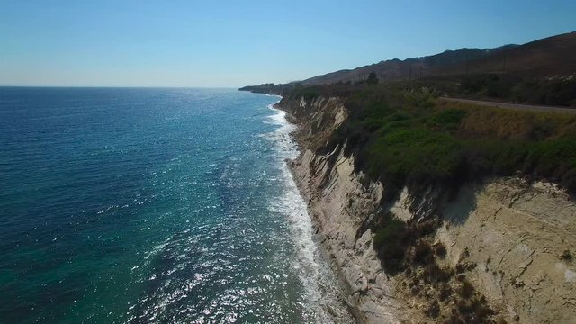 A beautiful long aerial shot along the rugged Central California coastline with sparkling ocean.