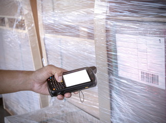 Warehouse worker hand holding barcode scanner with scanning on a product.