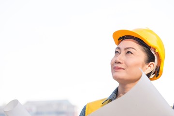 Woman in construction area wears safety hat on white background