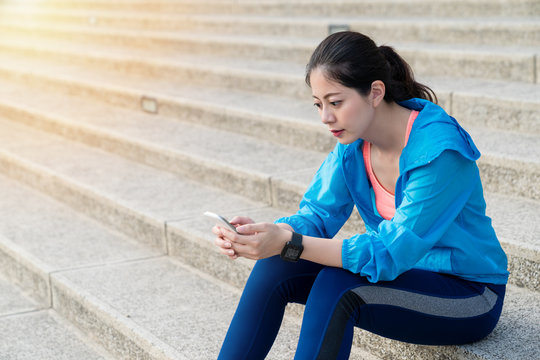 Woman sitting on stairs relaxing after running.