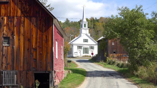 A charming small village scene in Vermont with church, road and farm.
