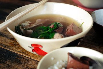 Thai style clear soup with congealed pork blood and rice on wooden table 