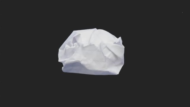 A crumpled piece of paper flattens out.