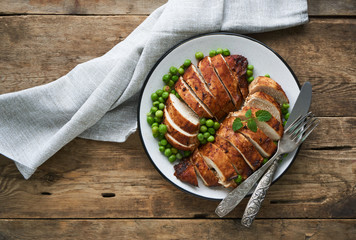 Baked chicken breast and green peas on a plate       