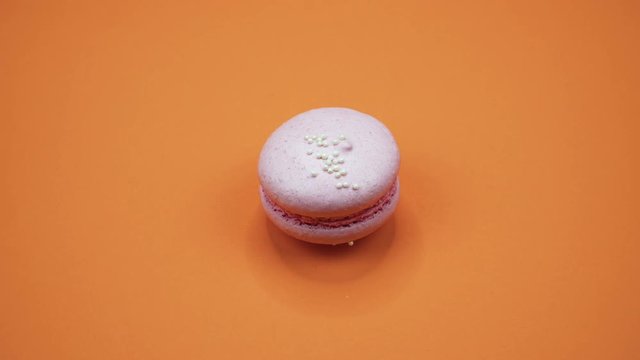 ROTATION: A Colorful Macaroons are rotating on a orange background