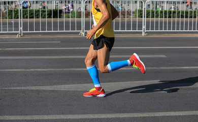Fototapeta premium marathon runner legs running on city road