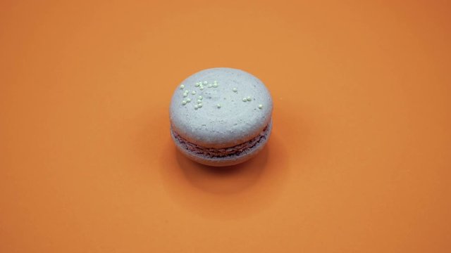 ROTATION: A Colorful Macaroons are rotating on a orange background