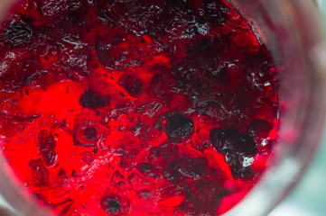 Bright translucent red currant jam in a glass jar