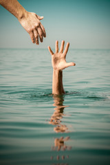 hand of help for drowning man life saving in sea water
