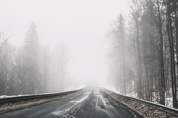 Foggy road in the mountains. Winter trip to Eastern Europe