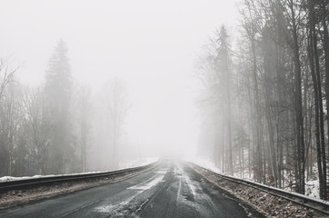 Obraz premium Foggy road in the mountains. Winter trip to Eastern Europe