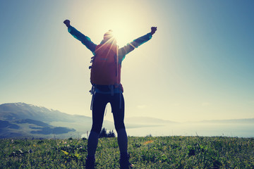 happy woman hiker on beautiful green mountain hill