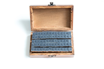 Wood box contain english alphabet and number rubber stamp on white background
