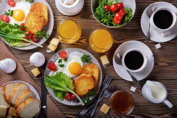 Fried eggs, croutons and salad with coffee and orange juice.